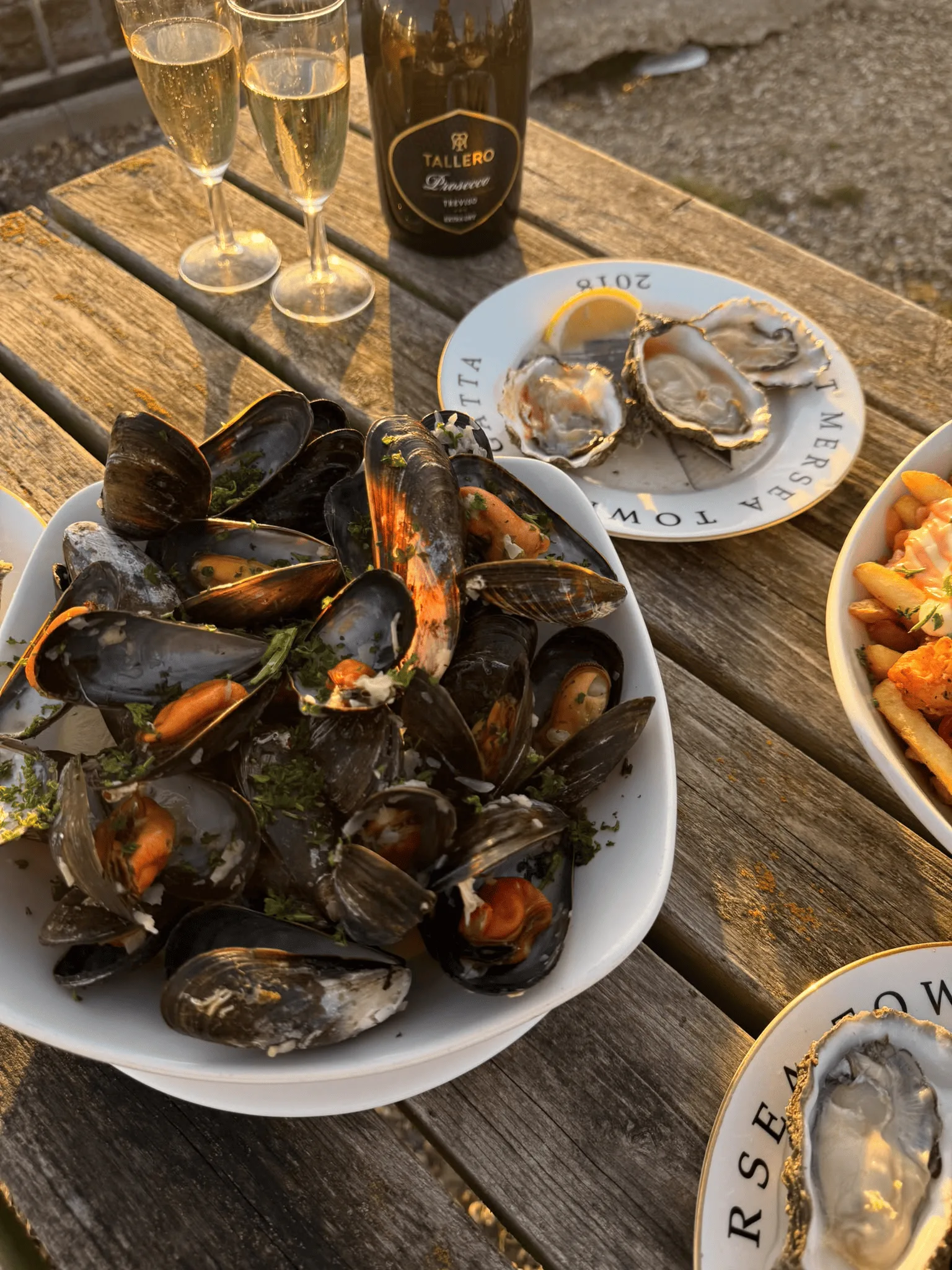 A bowl of mussels with garlic and herbs served at a waterside table